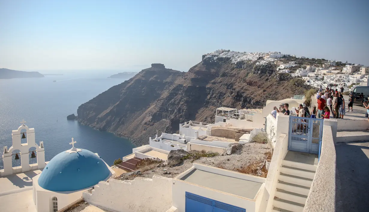 Santorini adalah persinggahan utama dalam pengalaman berlayar di Yunani. Namun karena sebagian dari pulau ini sudah hampir penuh, para pejabat sedang mempertimbangkan pembatasan. (Aris Oikonomou / AFP)