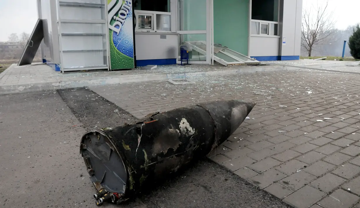 Bagian dari rudal terlempar hingga ke depan sebuah toko setelah ledakan gudang senjata di pangkalan militer Ukraina di Balakliya, Kamis (23/3). Sekitar 20.000 warga terpaksa dievakuasi akibat kejadian tersebut. (AP Photo/Mykhailo Andriiv)