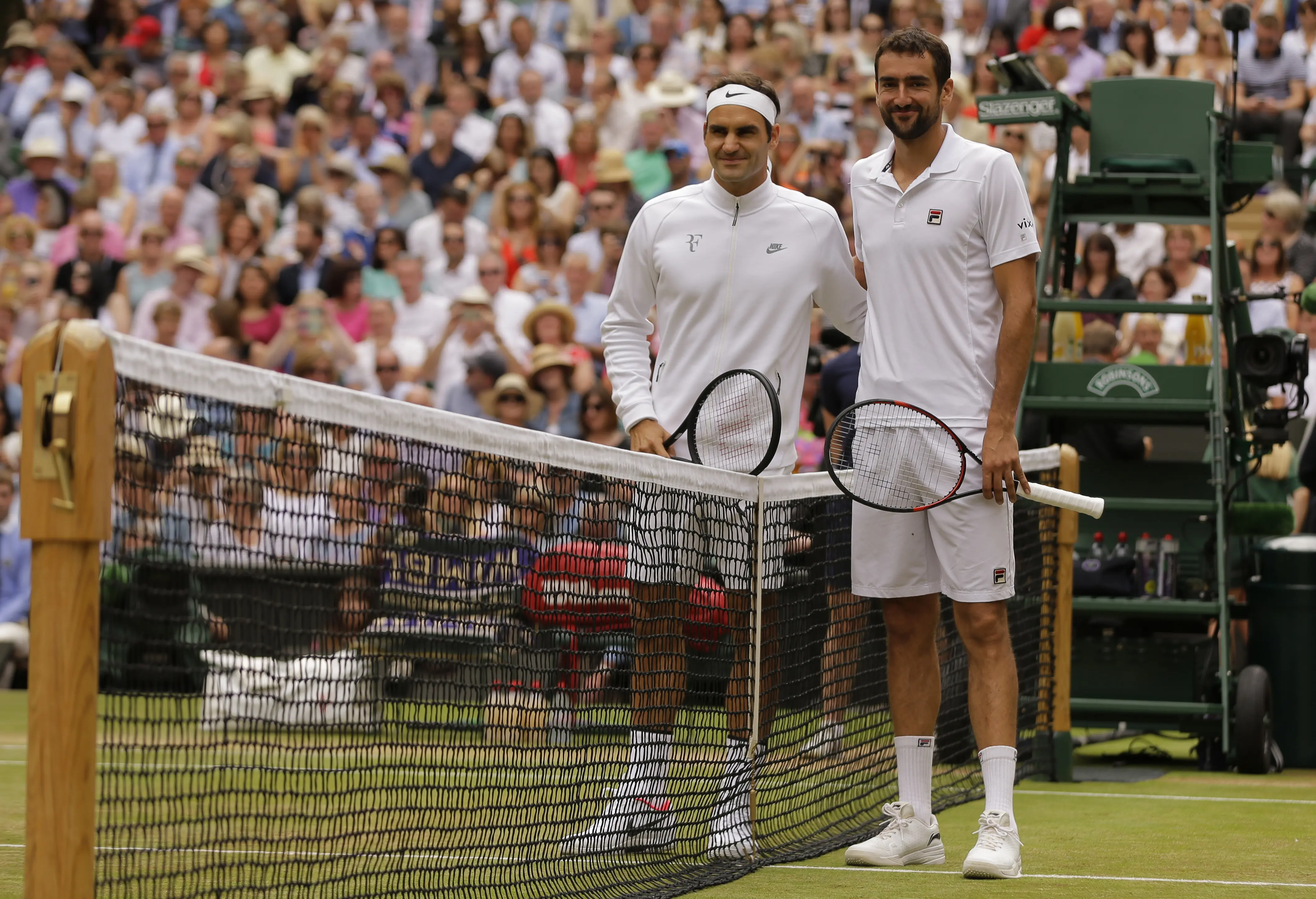 Roger Federer dan Marin Cilic berangkulan sebelum pertandingan dimulai (AP Photo/Tim Ireland)
