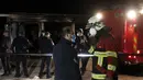 Petugas pemadam kebakaran berbicara satu sama lain berdiri di dekat rumah sakit darurat yang terbakar di kota Tetovo, Makedonia Utara, Kamis (9/9/2021). Kebakaran terjadi Rabu malam di rumah sakit darurat untuk pasien COVID-19. (AP Photo/Boris Grdanoski)