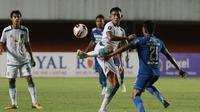 Bek Persebaya Surabaya, Rizky Ridho (tengah) mengontrol bola di depan striker Persib Bandung, Frets Butuan dalam laga perempatfinal Piala Menpora 2021 di Stadion Maguwoharjo, Sleman, Minggu (11/4/2021). Persebaya kalah 2-3 dari Persib. (Bola.com/M Iqbal I