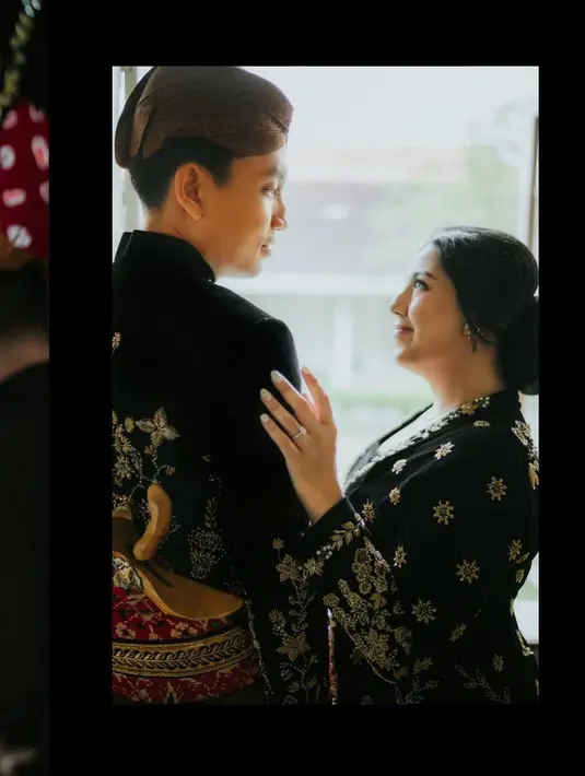 Sang suami, Andryan Gama, terlihat gagah kenakan beskap Jawa hitam emas. Lengkap dengan kain batik cokelat gelap dan keris [@nessiejudge]