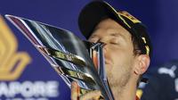 Pembalap Ferrari Sebastian Vettel berselebrasi di podium setelah memenangkan balapan Formula Satu (F1) Grand Prix Singapura di Sirkuit Jalan Marina Bay, Singapura (22/9/2019). Vettel berhasil menjuarai balapan dengan catatan waktu 1 jam:58menit:33.667 detik. (AP Photo/Vincent Thian)