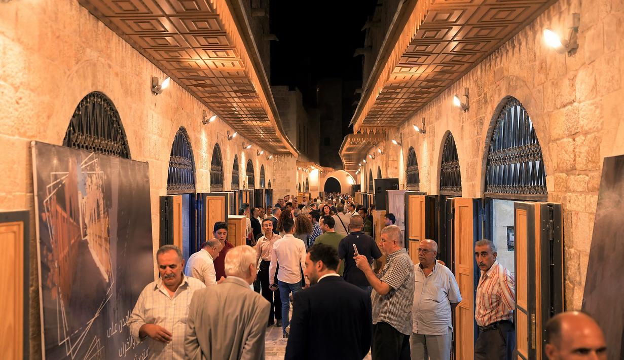 Orang-orang berjalan-jalan di "Souq Khan al-Harir" (pasar tertutup sutra) yang dibuka kembali setelah konflik bertahun-tahun di kota utara Aleppo, Suriah (29/8/2021). (AFP Photo)