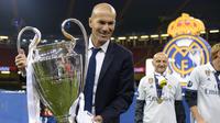 Pelatih Real Madrid, Zinedine Zidane, mengangkat trofi  usai memastikan diri sebagai juara Liga Champion dengan mengalahkan Juventus di Stadion Millennium, Cardiff, Sabtu (3/06/2017). Real Madrid menang 4-1. (AFP/ Filippo Monteforte)