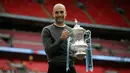 Manajer Manchester City Pep Guardiola berpose dengan trofi Piala FA 2018/2019 di Stadion Wembley, London, Inggris, Sabtu (18/5/2019). The Citizens menjuarai Piala FA 2018/2019 usai mengalahkan Watford dengan skor 6-0. (AP Photo/Tim Ireland)