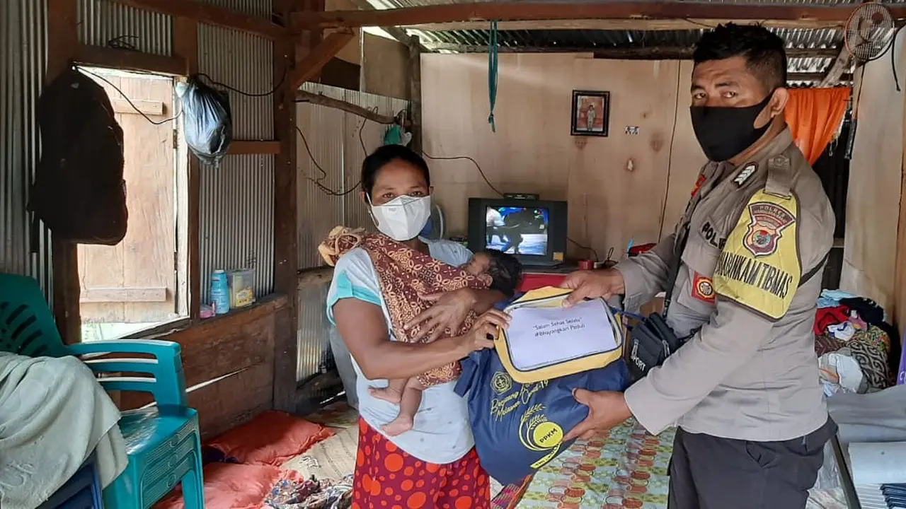 Salah satu anggota Bhabinkamtibmas, memberikan bantuan paket sembako dari TNI-Polri bagi warga kurang mampu di Manggarai Barat. (Foto Istimewah)