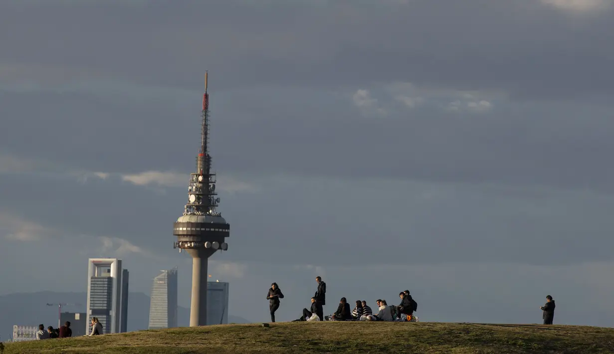 Orang-orang duduk di taman Cerro del Tio Pio di Madrid, Spanyol (14/10/2020). Berbagai wilayah di Spanyol, termasuk Navarra utara dan timur laut Catalonia, sedang merencanakan atau menerapkan pembatasan baru terhadap penyebaran virus corona baru. (AP Photo/Manu Fernandez)