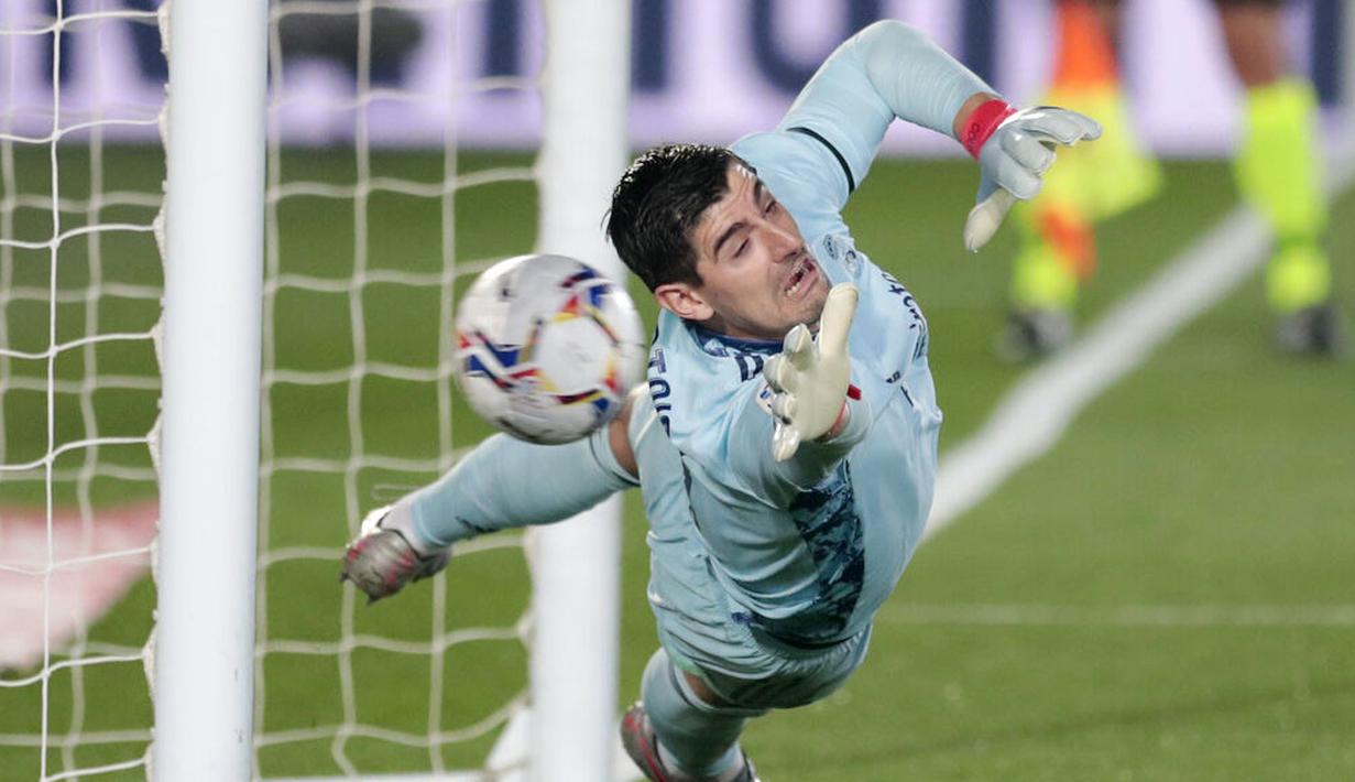 Kiper Real Madrid, Thibaut Courtois, gagal menghalau bola tendangan penalti pemain Alaves, Lucas Perez, pada laga Liga Spanyol di Stadion Alfredo di Stefano, Sabtu (28/11/2020). Real Madrid takluk dengan skor 1-2. (AP/Bernat Armangue)