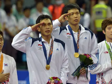 Muhamad Ahsan dan Hendra Setiawan memberi hormat sambil menyanyikan lagu Indonesia Raya di Gyeyang Gymnasium, Korsel, (28/9/2014). (ANTARA FOTO/Saptono)