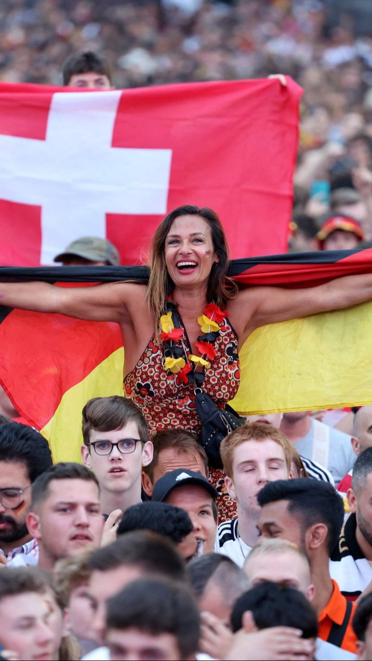 Suporter cantik Jerman membentangkan bendera saat mendukung langsung Tim Panser.&nbsp;Foto: AFP