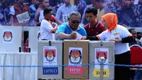 Seorang Tuna Netra di bantu petugas KPPS memasukan surat suara yang telah di pilih dalam simulasi pengamanan TPS di Mapolda Metro Jaya, Jakarta, Senin (07/04). Foto/Liputan6.com : Andrian Martinus Tunay
