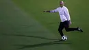Pelatih Real Madrid, Zinedine Zidane berusaha menendang bola saat mengikuti sesi latihan di Abu Dhabi, Uni Emirat Arab, (14/12). Real Madrid akan bertanding melawan klub Brasil Gremio di pertandingan final Piala Dunia Klub 2017. (AP Photo / Hassan Ammar)