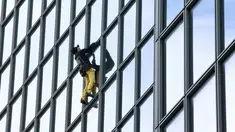 Alain Robert ketika memanjat gedung di pusat bisnis La Defense, Paris, Prancis, Senin (21/3/2016). Pria yang dijuluki 'Spiderman' ini telah memanjat lebih dari 70 gedung tertinggi di dunia. (Jacques DEMARTHON/AFP)