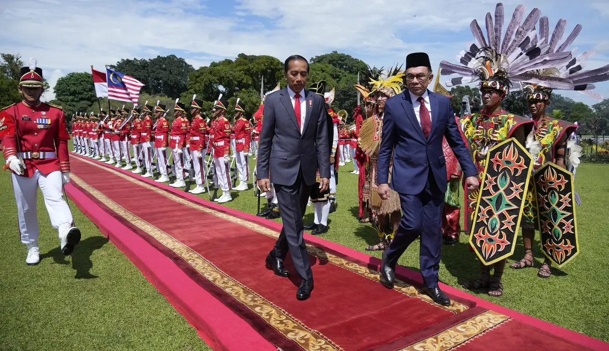 Presiden Joko Widodo atau Jokowi (kiri) bersama Perdana Menteri Malaysia Anwar Ibrahim (kedua kiri) memeriksa pasukan di Istana Kepresidenan Bogor, Jawa Barat, Senin (9/1/2023). Kedatangan Anwar Ibrahim diiringi arak-arakan pasukan berkuda dan marching band. (AP Photo/Achmad Ibrahim)