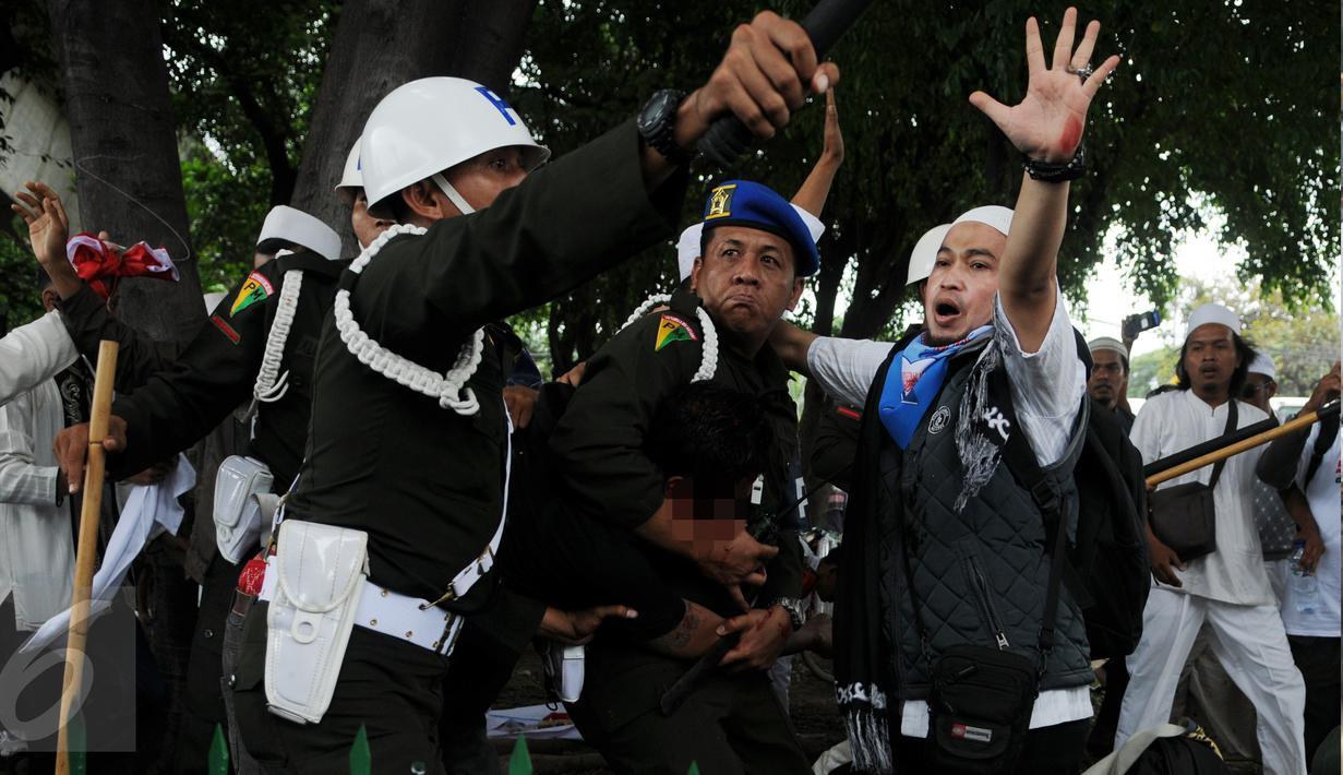 Seorang pria yang diduga provokator dalam aksi damai 2 Desember ditangkap oleh polisi Militer Angkatan Laut di kawasan Monas, Jakarta, Jumat (2/12). Pria itu tertangkap tangan membawa golok saat aksi damai tengah berlangsung. (Liputan6.com/Gempur M Surya)