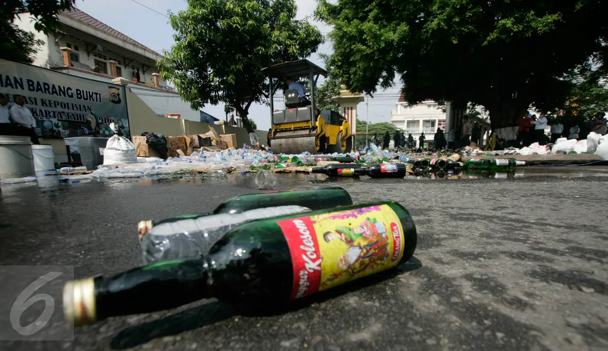 Alat berat melindas ribuan botol minuman keras (miras) saat pemusnahan barang bukti di halaman Mapolda DIY, Senin (6/6). Semua barang bukti yang dimusnahkan petugas merupakan hasil Operasi Pekat yang digelar sebelum Ramadan. (Liputan6.com/Boy Harjanto)