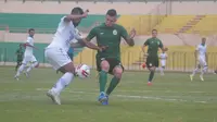 Perebutan bola antara bek PSS Sleman, Aaron Evans (hijau) dengan striker Persib Bandung, Zulham Zamrun dalam laga uji coba di Stadion Sultan Agung, Bantul, Senin (17/2/2020). (Bola.com/Vincentius Atmaja)