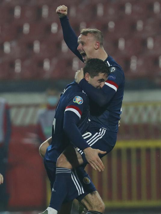 Pemain Skotlandia Leigh Griffiths (kanan) digendong oleh Kenny McLean saat mereka merayakan kemenangan atas Serbia pada pertandingan playoff Euro 2020 di Stadion Rajko Mitic, Beograd, Serbia, Kamis (12/11/2020). (AP Photo/Darko Vojinovic)