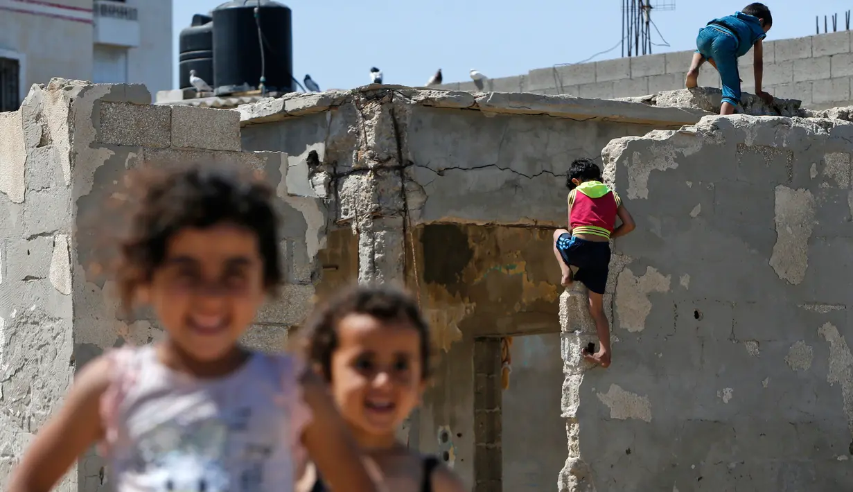 Anak-anak bermain saat Hari Nakba di sebelah rumah mereka di kamp pengungsian Al-Shati, Jalur Gaza, Palestina, Rabu (15/5/2019). Hari Nakba di mana ratusan ribu rakyat Palestina eksodus dari tanah kelahirannya telah mengubah kehidupan mereka selama tujuh dekade terakhir. (MOHAMMED ABED/AFP)