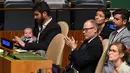 Clarke Gayford menggendong sang putri, Neve Te Aroha Ardern Gayford saat istrinya yang juga PM Selandia Baru, Jacinda Ardern berbicara dalam pertemuan  Nelson Mandela Peace Summit di markas PBB, New York, Senin (24/9). (AFP/Don EMMERT)