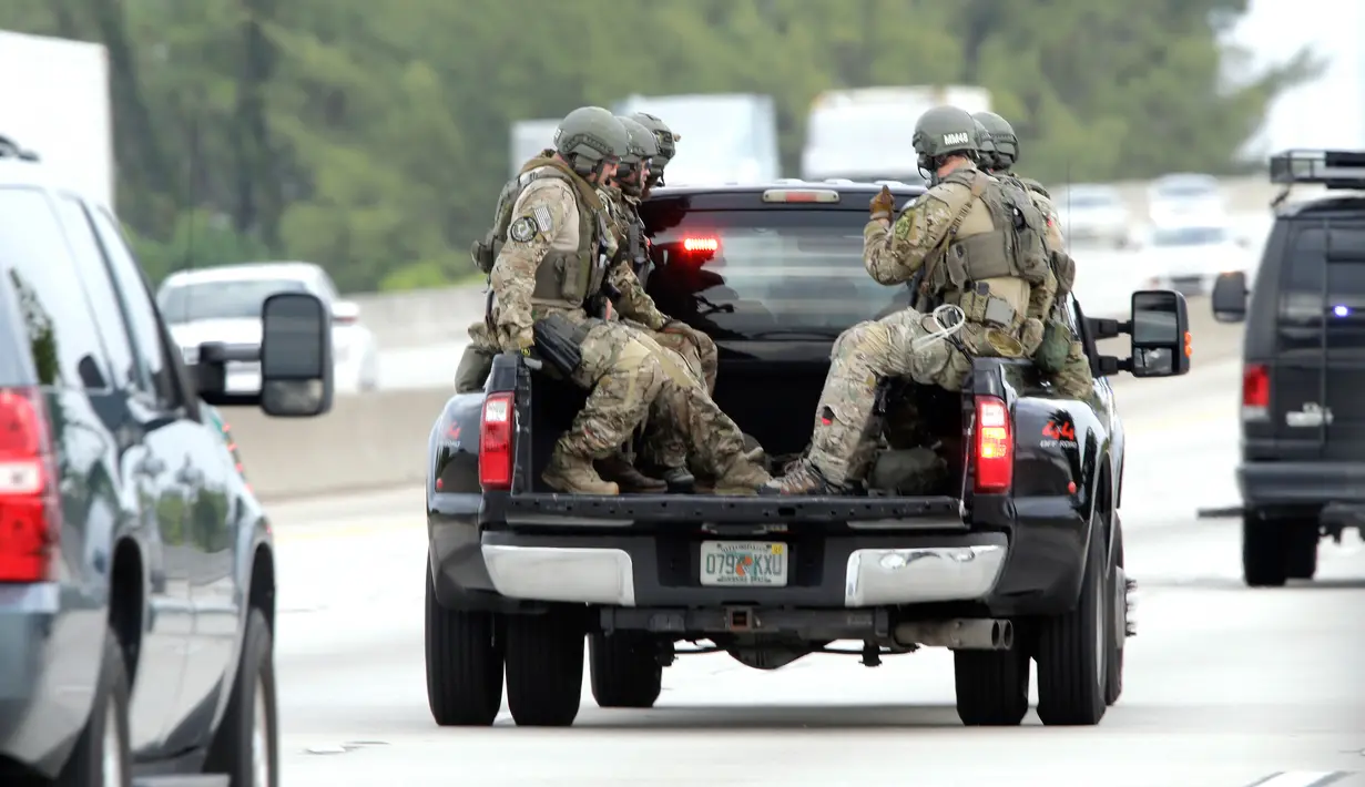 Sejumlah polisi mengenakan kendaraan berjaga saat terjadi penembakan di Bandara Fort Lauderdale, Florida, AS (6/1). Peristiwa penembakan terjadi di tempat pengambilan bagasi bandara di Terminal 2. (AP Photo/Alan Diaz)