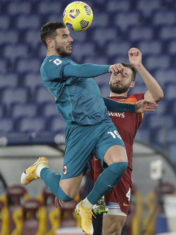 Bek AC Milan, Theo Hernandez berebut bola dengan gelandang AS Roma, Bryan Cristante pada pertandingan lanjutan Liga Serie A Italia di stadion Olimpiade, Italia,Senin (1/3/2021). Hasil ini membuat AC Milan menempel ketat rival mereka Inter Milan  di puncak klasemen. (AP Photo/Gregorio Borgia)
