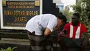 Seorang pencari suaka diperiksa kesehatannya di trotoar depan Rumah Detensi Imigrasi Kalideres, Jakarta, Jumat (19/1). Selama 17 minggu, sebanyak 57 WNA tinggal di trotoar karena ruangan Rumah Detensi Imigrasi tersebut penuh. (Liputan6.com/JohanTallo)