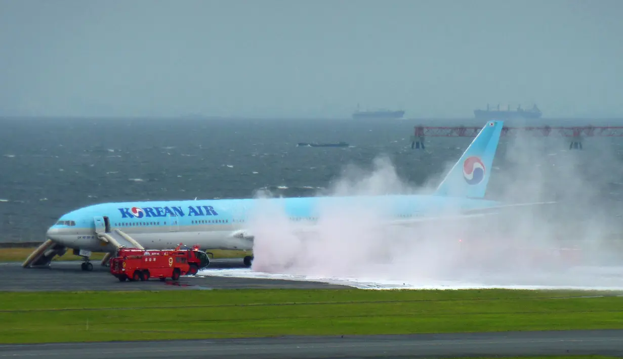Pesawat Korean Air Lines saat mengeluarkan asap dari bagian mesin pesawat sebelah kiri di bandara Haneda di Tokyo, Jepang, (27/5). Pesawat pembawa 319 penumpang ini bersiap untuk lepas landas dari Jepang. (Reuters/ Kyodo)