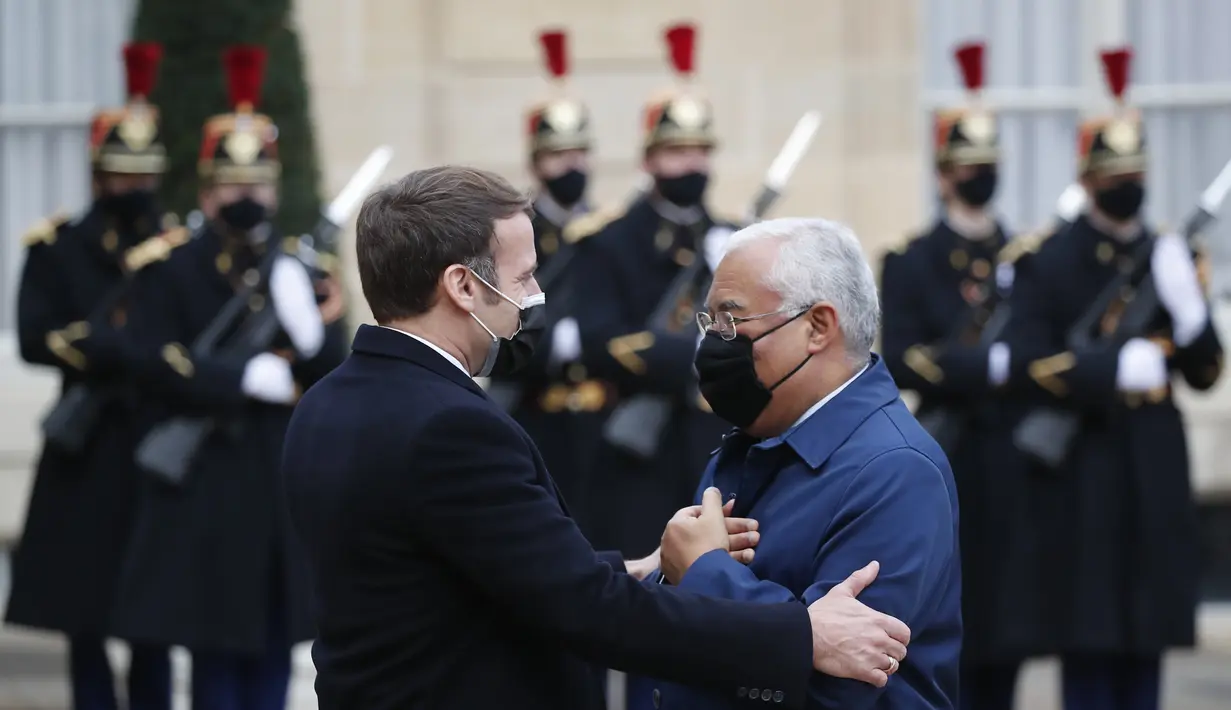 Presiden Prancis Emmanuel Macron (kiri) menyambut Perdana Menteri Portugis Antonio Costa di halaman Istana Elysee, sebelum makan siang kerja di Paris, Rabu (16/12/2020). Ini adalah kesekian kalinya pemimpin negara terinfeksi Covid-19. (AP Photo/Francois Mori)