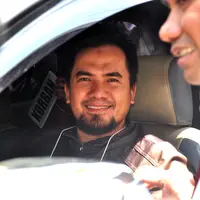 Penyanyi dangdut yang tersangkut kasus pelecehan seksual Saipul Jamil tersenyum di mobil saat menjalani rekonstruksi. (Adrian Putra/Bintang.com)