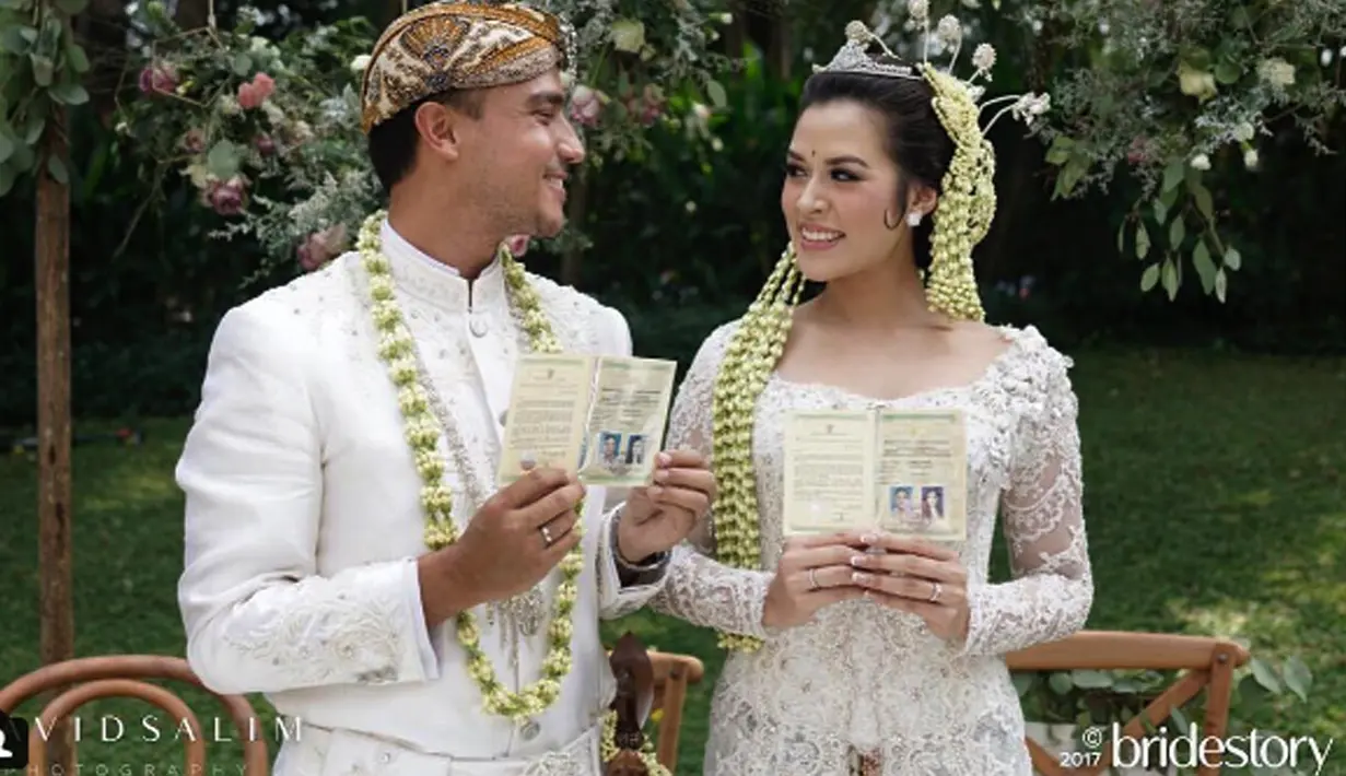 Penyanyi Raisa dan Hamish Daud menunjukkan buku pernikahan usai melangsungkan akad nikah. Minggu 3 September 2017 menjadi hari terindah Raisa dan Hamish Daud. Mereka mengikat janji suci sehidup semati. (Instagram/thebridestory)