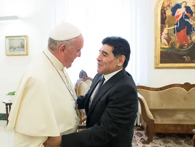Paus Fransiskus (kiri) bersalaman dengan mantan pesepak bola Argentina, Diego Armando Maradona sebelum pertemuan dengan anggota organisasi Scholas Occurentes di Vatikan pada tanggal 4 September 2014. (AFP/Filippo Monteforte)