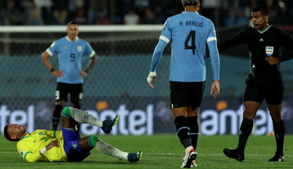 Neymar tampak seperti salah tumpuan saat berebut bola dengan pemain Uruguay. (Pablo PORCIUNCULA / AFP)