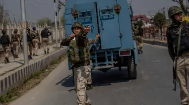 Seorang tentara paramiliter India menggunakan ketapel selama bentrok dengan pengunjuk rasa selama protes terhadap pembunuhan pemberontak di Srinagar, Kashmir yang dikuasai India, (1/4). (AP Photo / Dar Yasin)