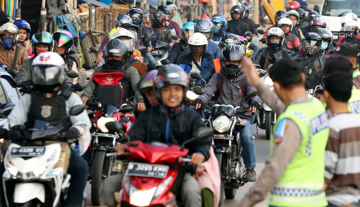 Polisi mengatur arus lalu lintas pemudik sepeda motor di Jalur Pantura Indramayu - Cirebon, Jawa Barat, Jumat (23/6). Iring-iringan pemudik bersepeda motor di sepanjang jalur pantura Indramayu - Cirebon mengular pada H-2 Lebaran (Liputan6.com/Johan Tallo)