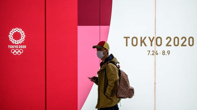 Seorang pria mengenakan masker pelindung berjalan di terowongan sebuah stasiun metro di Tokyo, Jepang, 11 Maret 2020. Pandemi virus corona COVID-19 membuat Jepang dilema untuk tetap menggelar Olimpiade 2020. (Photo by Philip FONG/AFP)