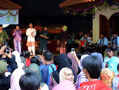 Sejumlah pengunjung menyaksikan kesenian gambang kromong di pusat budaya Setu Babakan, Depok, Senin (20/7/2015). Kesenian Betawi merupakan salah satu alternatif hiburan warga mengisi libur Lebaran. (Liputan6.com/Helmi Afandi)