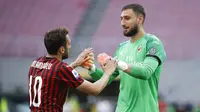 Pemain AC Milan Hakan Calhanoglu dan Gianluigi Donnarumma merayakan kemenangan atas AS Roma pada laga Serie A di Stadion San Siro, Minggu (28/6/2020). AC Milan menang 2-0 atas AS Roma. (AP/Luca Bruno)