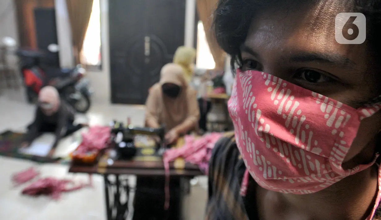 Seseorang memakai masker kain buatan ibu-ibu PKK di Desa Bojongkulur, Gunung Putri, Bogor, Jawa Barat, Kamis (9/4/2020). Saat pelaksanaan isolasi mandiri akibat COVID-19, ibu-ibu PKK ini membuat masker untuk dibagikan secara gratis kepada warga sekitar. (merdeka.com/Arie Basuki)