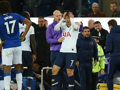 Striker Tottenham Hotspur Son Heung-min (tengah) memegangi kepalanya setelah menekel gelandang Everton Andre Gomes pada pertandingan Liga Inggris di Goodison Park, Liverpool, Inggris, Minggu (3/11/2019). Tekel Son Heung-min menyebabkan Andre Gomes patah kaki. (Oli SCARFF/AFP)