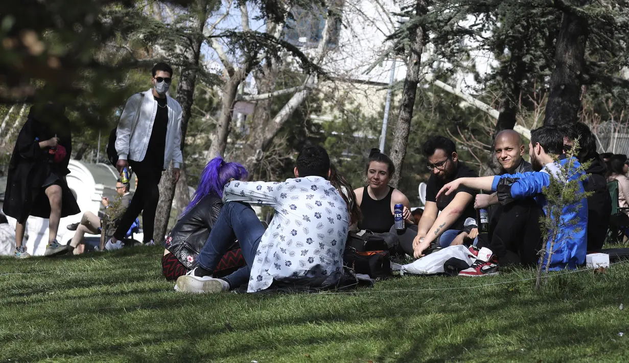 Orang-orang tanpa masker dan mengabaikan aturan jarak sosial, duduk di taman berjam-jam sebelum penguncian nasional, di Ankara, Rabu (21/4/2021). Turki terus mencatat rekor kematian harian COVID-19 tertinggi pada hari Rabu, dengan 362 kematian terdaftar dalam 24 jam terakhir. (AP/Burhan Ozbilici)