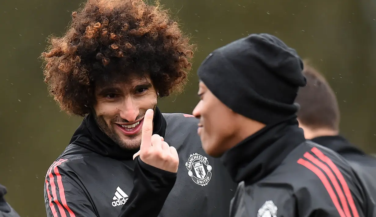 Gelandang Manchester United, Marouane Fellaini, berbincang dengan Anthony Martial saat latihan jelang laga Liga Champions di Manchester, Senin (12/3/2018). Manchester United akan berhadapan dengan Sevilla. (AFP/Oli Scarff)