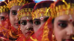 Sejumlah wanita calon pengantin bersiap mengikuti upacara pernikahan massal di Kolkata, India (14/2). Lebih dari 160 pasangan yang mengalami kesulitan ekonomi mengikuti acara nikah massal tersebut. (AFP Photo/Dibyangshu Sarkar)