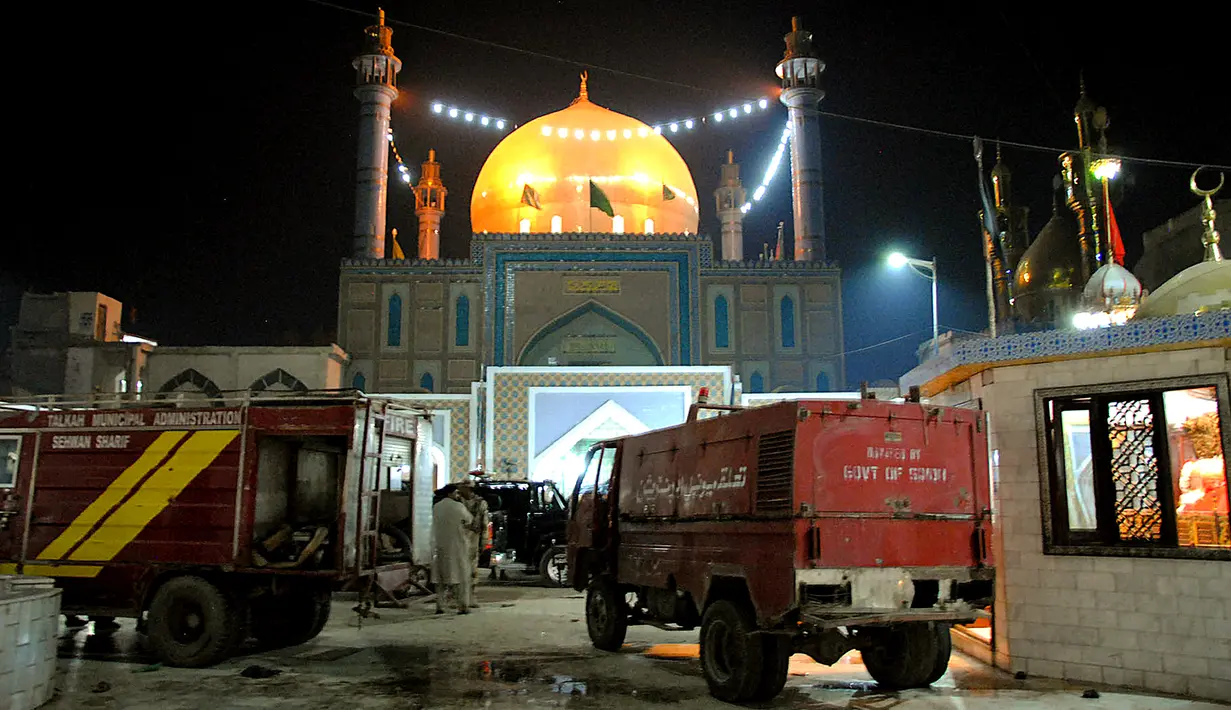 Mobil pemadam bersiaga di depan lokasi serangan bom di tempat suci Lal Shahbaz Qalandar di Provinsi Sindh, Pakistan selatan, Kamis (16/2). Pelaku masuk ke ruang utama rumah suci kemudian meledakkan diri di tengah puluhan jamaah. (YOUSUF NAGORI/AFP)