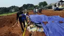 Warga memeriksa tempat penemuan beras diduga bansos presiden di kawasan Kampung Serab, Sukmajaya, Depok, Jawa Barat, Rabu (3/8/022). Dari berita acara pemendaman, diketahui beras yang dikubur sebanyak 3.675 kg atau 289 karung. (merdeka.com/Arie Basuki)