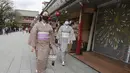 Pengunjung berpakaian kimono yang mengenakan masker untuk melindungi diri dari penyebaran virus corona berjalan-jalan di distrik Asakusa di Tokyo, Jepang, Rabu (14/10/2020). Tokyo mengonfirmasi lebih dari 170 kasus virus corona baru pada hari Rabu. (AP Photo/Koji Sasahara)