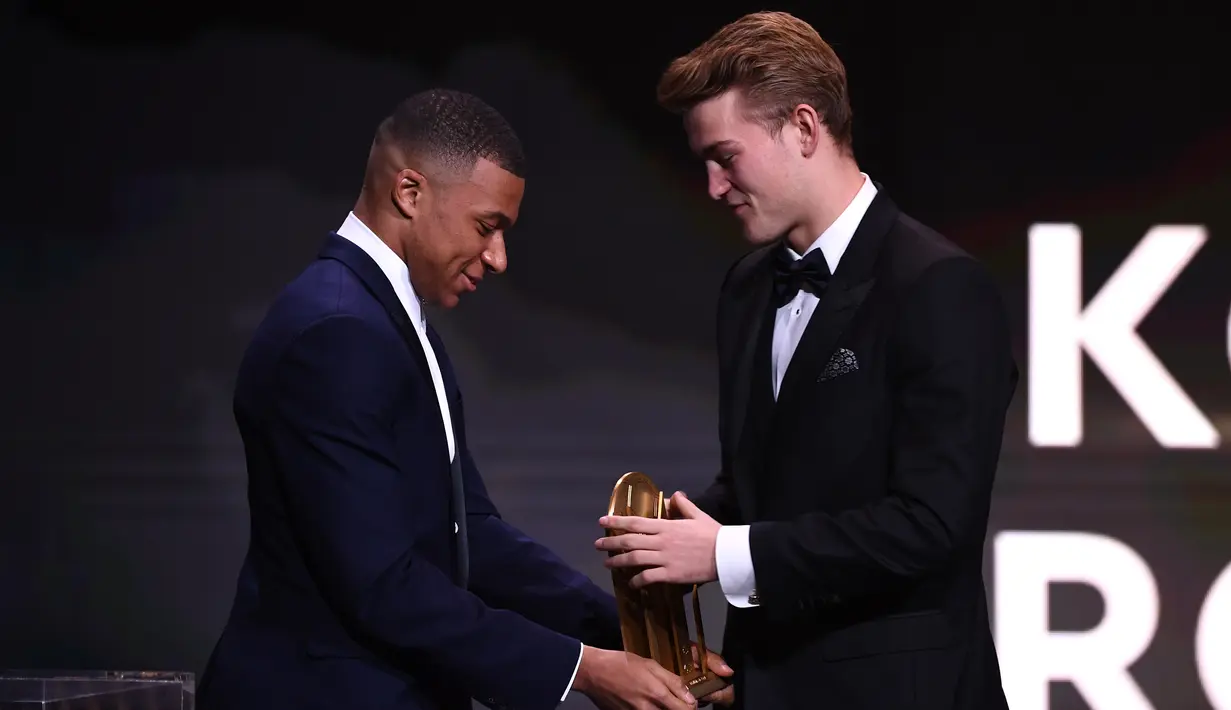 Pemain Juventus Matthijs de Ligt (kanan) meraih piala Kopa Trophy pada malam penghargaan Ballon d'Or 2019 di Chatelet Theatre, Paris, Prancis, Senin (2/12/2019). De Ligt dinobatkan sebagai pemain muda U21 terbaik di dunia. (FRANCK FIFE/AFP)