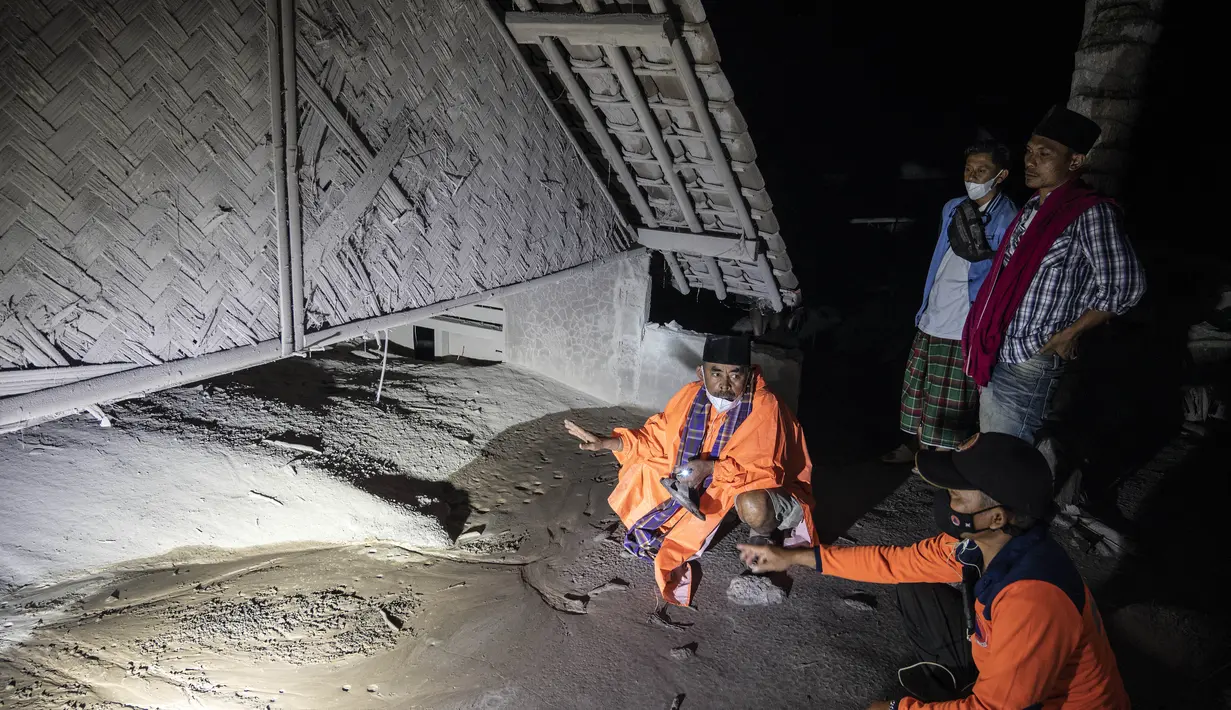 Warga dan tim penyelamat memeriksa area yang tertutup abu vulkanik dalam upaya mencari korban atau jenazah pasca erupsi Gunung Semeru di Desa Sumber Wuluh, Lumajang, Minggu (5/12/2021). (AFP/Juni Kriswanto)