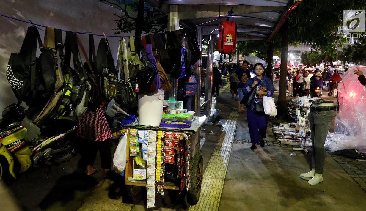 Seorang warga berjalan di trotoar yang dijadikan tempat berjualan pedagang kaki lima (PKL) di Kawasan Bendungan Hilir, Jakarta Pusat, Selasa (30/1). Para PKL ini menggelar dagangannya di bahu jalur pendestrian. (Liputan6.com/JohanTallo)